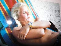 Young nudists rub oil on each other's naked bodies