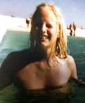 Young nudists rub oil on each other's naked bodies