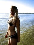 Young nudists rub oil on each other's naked bodies