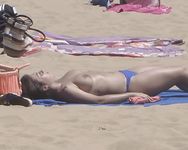 Zonnebaden op een gestreepte handdoek bij een zomernaturistenkamp in Frankrijk