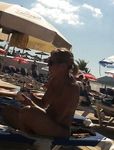 Zonnebaden op een gestreepte handdoek bij een zomernaturistenkamp in Frankrijk