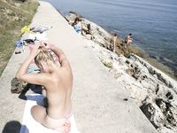 Amici nudi si divertono liberamente su una spiaggia pubblica