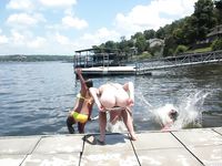 Verspielter Strandmoment nahe den Wellen mit sanftem Zug am Bikini-Unterteil