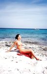 girl nudist kicks up some water at a nude beach