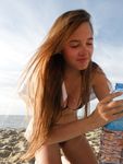 Zand op haar huid tussen groen en een helderblauwe lucht