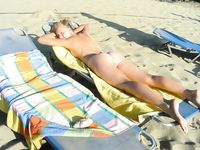 Adult nudist babe lights up at the beach