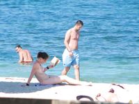 Adult nudist babe lights up at the beach