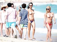 Cappello di piume e bracciali sulla riva sabbiosa di una spiaggia naturista