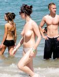 Topless on the Sand With a White Cloth and Beach Umbrellas