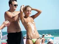 Topless on the Sand With a White Cloth and Beach Umbrellas