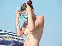 Topless on the Sand With a White Cloth and Beach Umbrellas