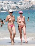Topless on the Sand With a White Cloth and Beach Umbrellas