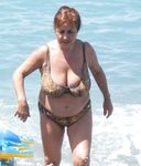 Seduta con un telo su una tranquilla spiaggia naturista