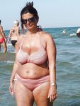 Seduta con un telo su una tranquilla spiaggia naturista