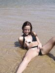 Two Women With Wet Hair Stand Together on a Sunny Beach