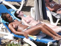 Two Women With Wet Hair Stand Together on a Sunny Beach