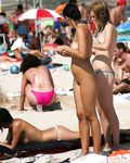 She Adjusts Her Striped Bikini Top on a Bright Sunny Beach