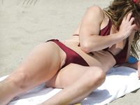 Kneeling and Smiling on a Sunny Nude Beach