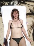 Kneeling and Smiling on a Sunny Nude Beach
