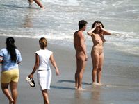 Kneeling and Smiling on a Sunny Nude Beach