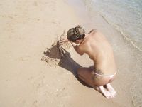 Two Nude Women Walk Together on a Sunlit Public Beach