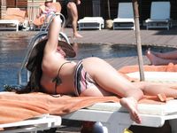 Topless Sunbathing With the Ocean Stretching Behind Her
