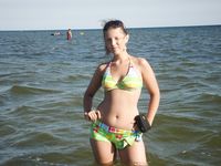 Topless Sunbathing With the Ocean Stretching Behind Her
