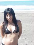 Topless Sunbathing With the Ocean Stretching Behind Her