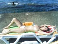 A pair of nudist adult friends steam up the beach