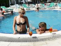 A pair of nudist adult friends steam up the beach