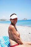 A pair of nudist adult friends steam up the beach