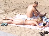Two Women Lounge Topless in an Outdoor Pool