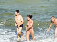 Carrying a Blue Inflatable Ring Along a Nude Beach