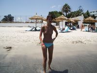 Toalha amarela numa praia rochosa sob o sol quente de verão