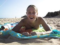 She Poses With Quiet Confidence on a Sandy Beach by Clear Water