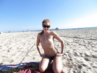 She Poses With Quiet Confidence on a Sandy Beach by Clear Water