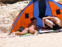 Laughing and Untying a Red Bikini Top on a Topless Beach