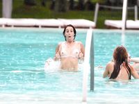 Curvy adult bares all at a nudist beach in the sun