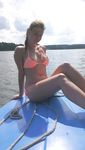 girl nudist kicks up some water at a nude beach