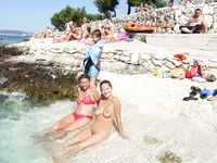 girl nudist kicks up some water at a nude beach