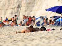 A Sun-Kissed Nude Sunbather With Sand on Her Feet