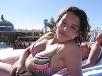 Slim girl with perky boobs naked at a nudist beach