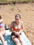 Slim girl with perky boobs naked at a nudist beach