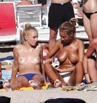 Relaxed and Seated on the Nude Beach in Sunglasses