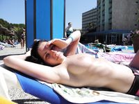 Relaxed and Seated on the Nude Beach in Sunglasses