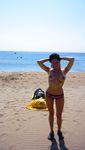 Relaxed and Seated on the Nude Beach in Sunglasses