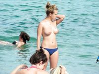 An Easy Stroll for Three Nudists Along Sandy Shoreline