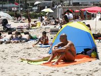 Heating up the beach by exposing her nude figure