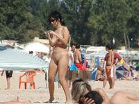 Heating up the beach by exposing her nude figure