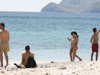 Heating up the beach by exposing her nude figure